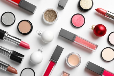 Flat lay composition with makeup products and Christmas decor on white background