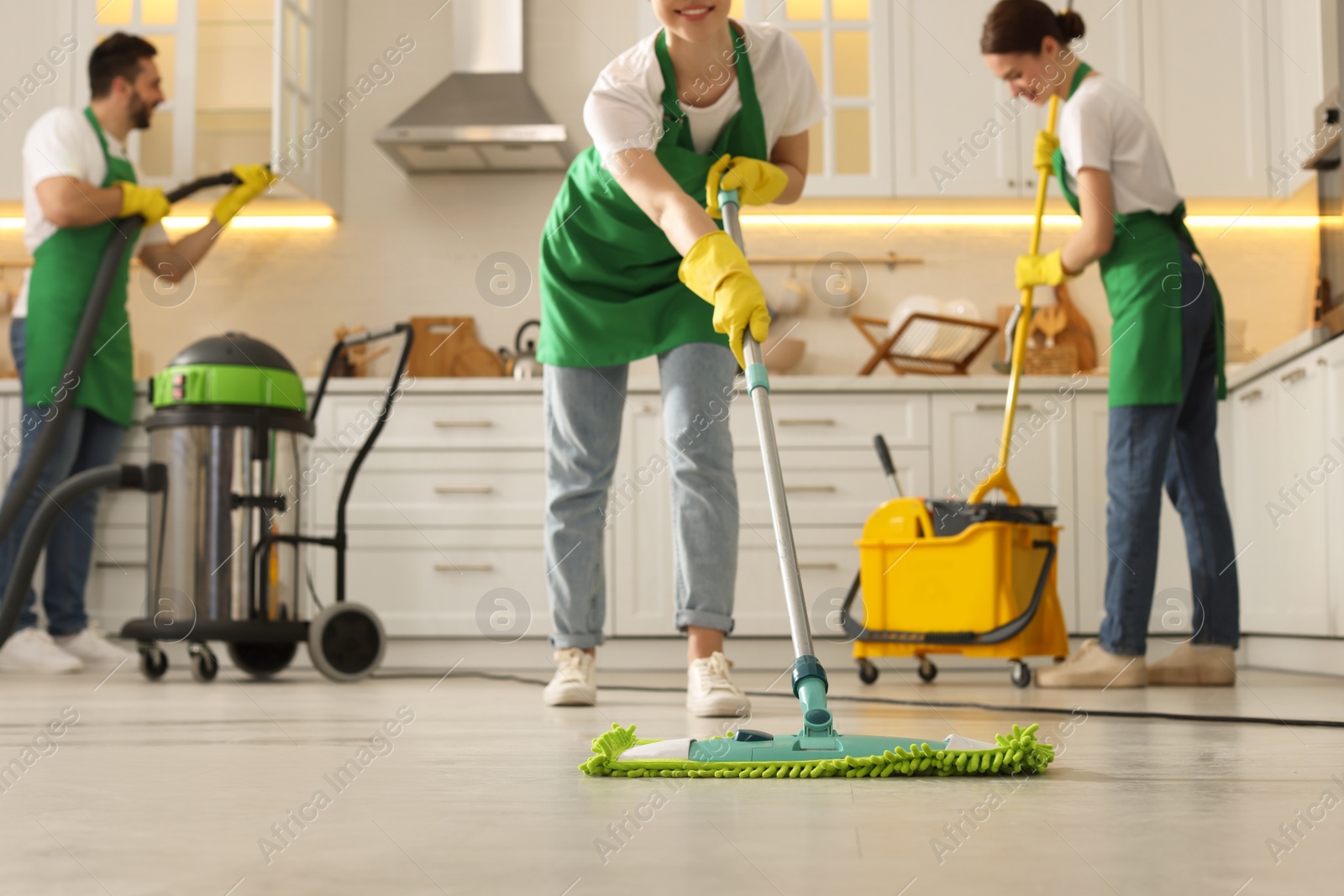 Photo of Professional janitors working in kitchen, closeup. Cleaning service