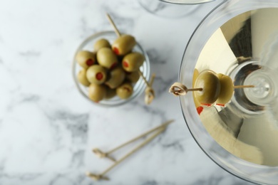 Photo of Flat lay composition with glass of Classic Dry Martini and olives on white marble table