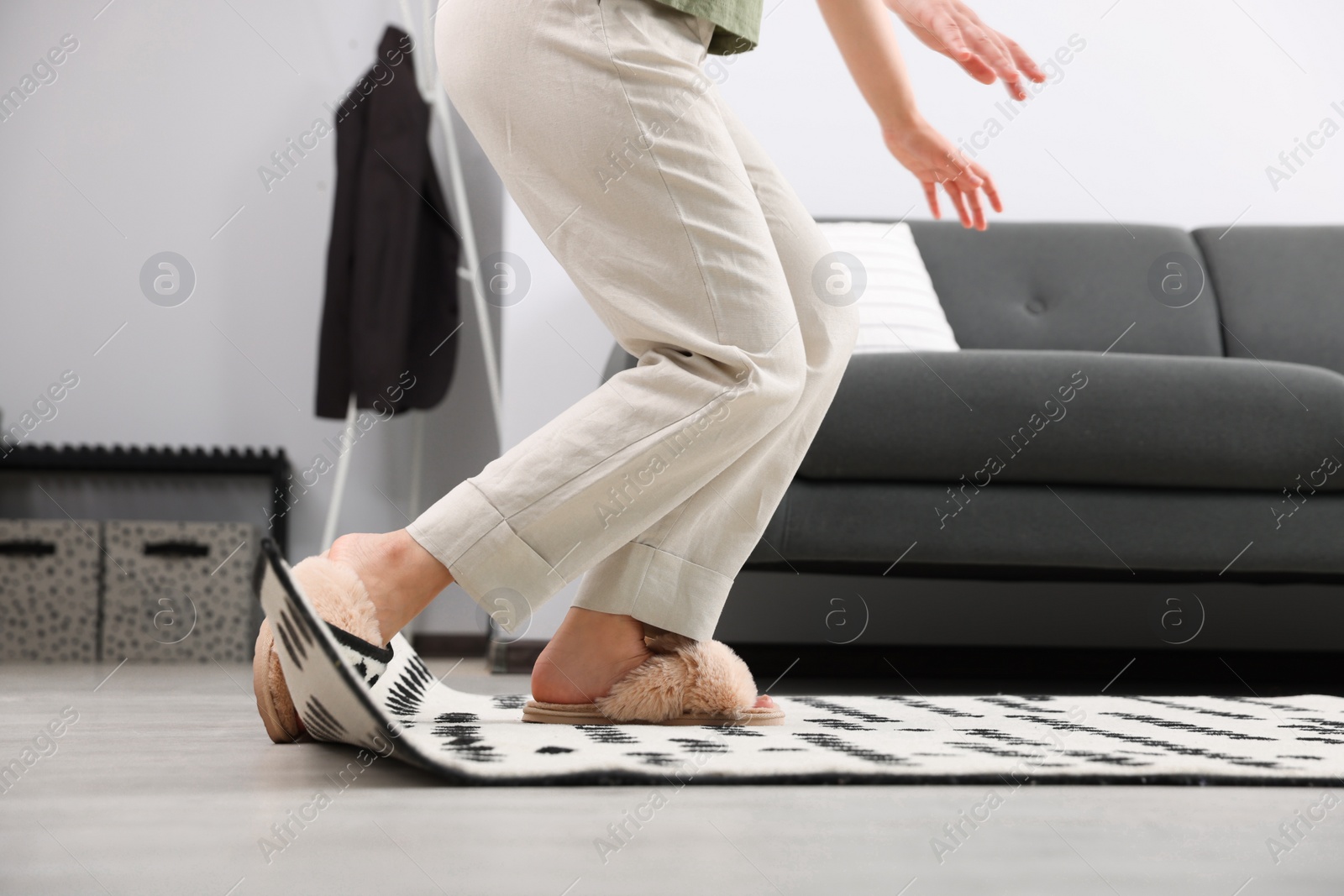 Photo of Woman tripping over carpet at home, closeup