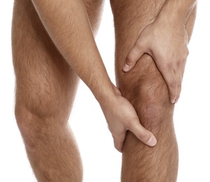 Man suffering from knee pain on white background, closeup