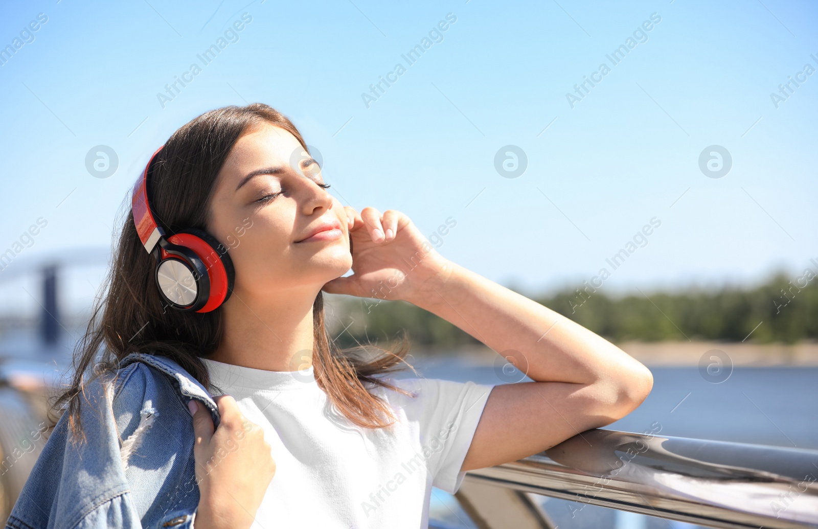 Photo of Young woman with headphones listening to music outdoors