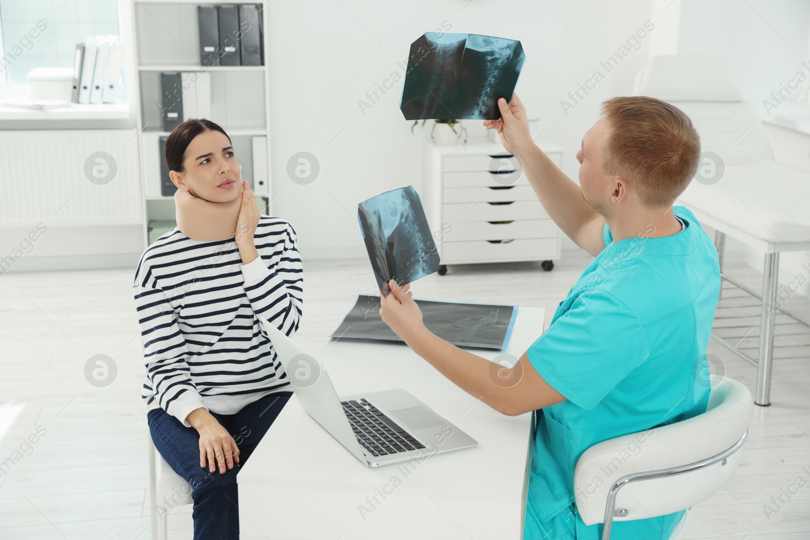 Photo of Doctor with neck MRI images consulting patient in clinic