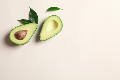 Photo of Ripe sliced avocado on light background