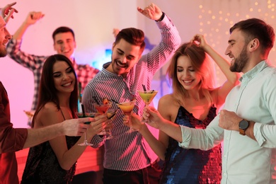 Photo of Group of young people holding martini cocktails at party