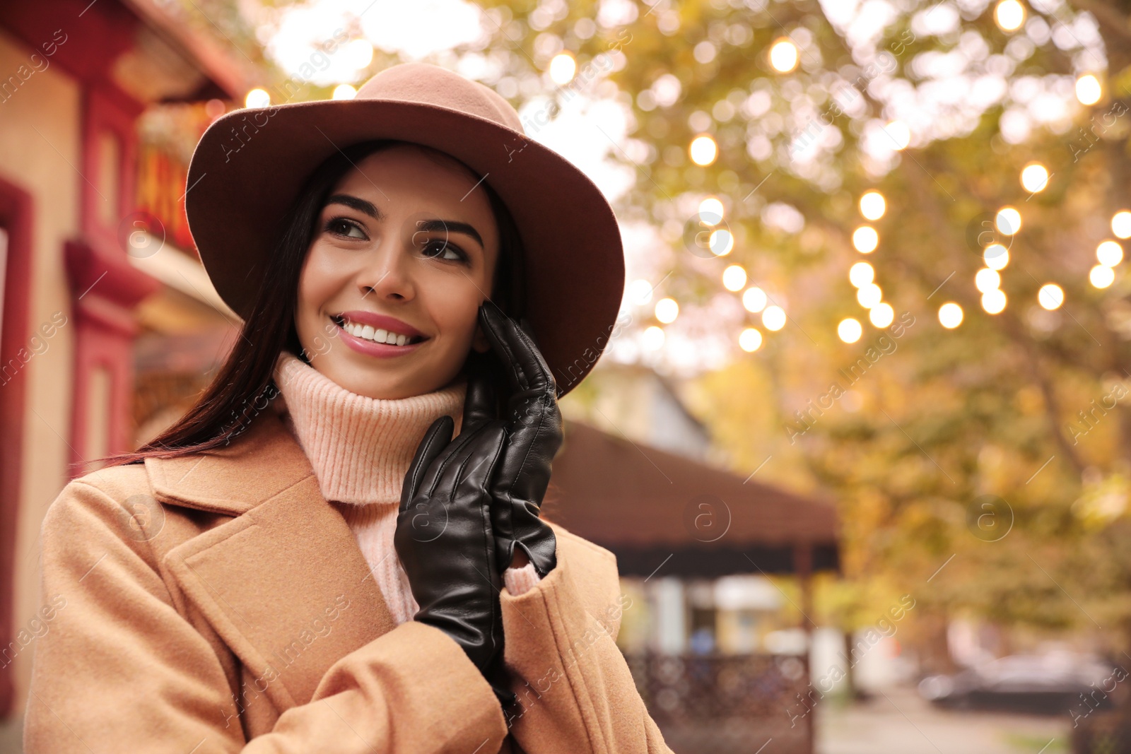 Photo of Young woman wearing stylish clothes on city street, space for text. Autumn look