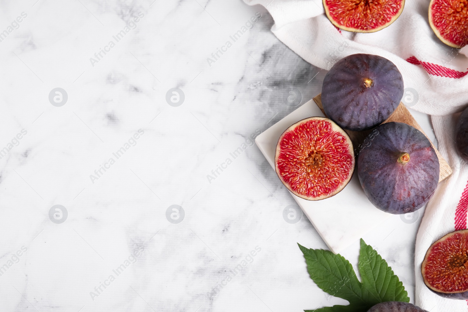 Photo of Fresh ripe purple figs on white marble table, flat lay. Space for text