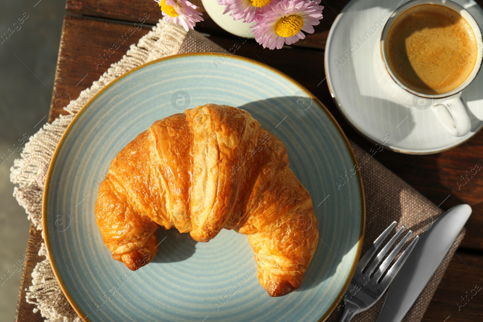 Photo of Delicious fresh croissant served with coffee on wooden table, flat lay