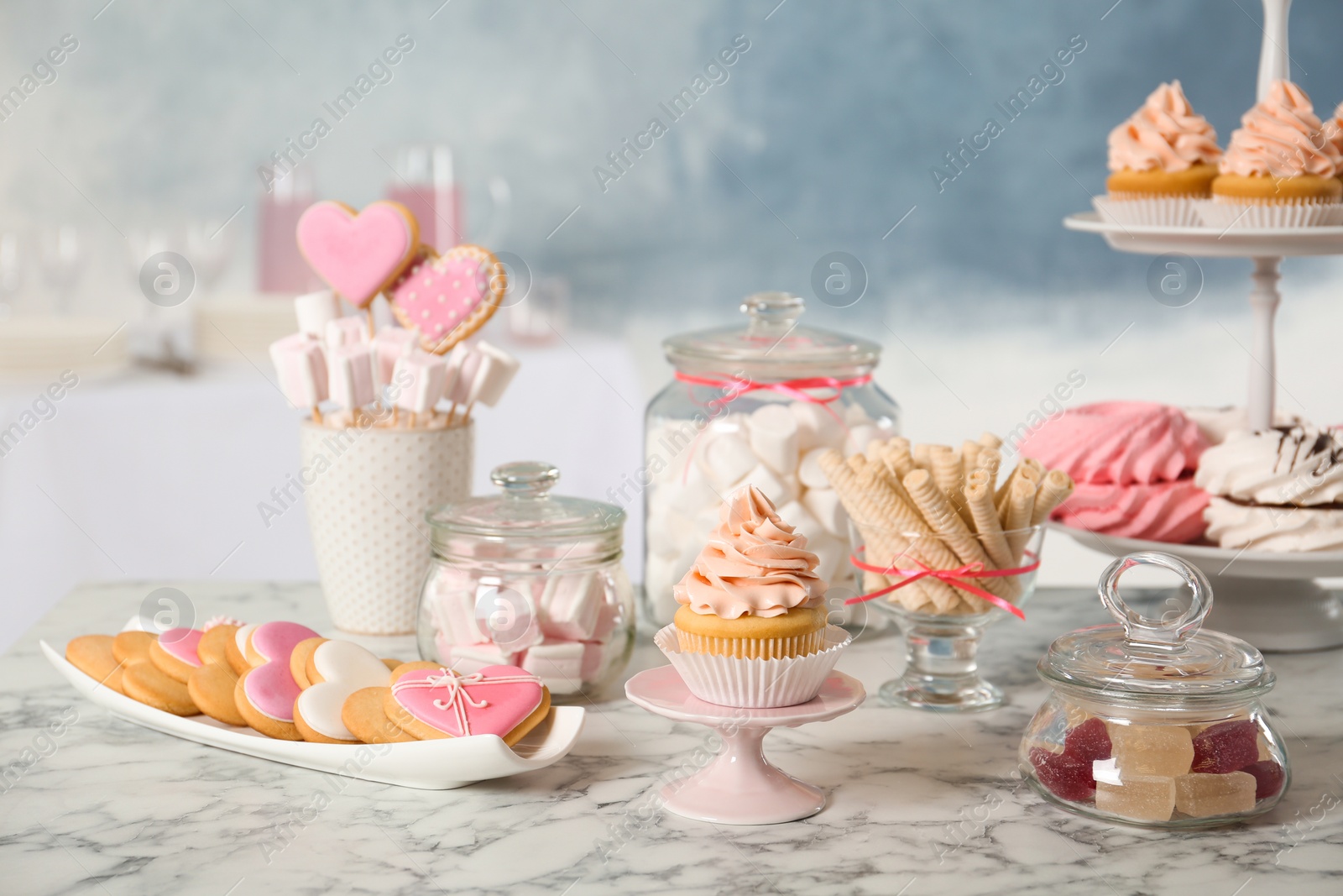 Photo of Candy bar with different sweets on white marble table against color background