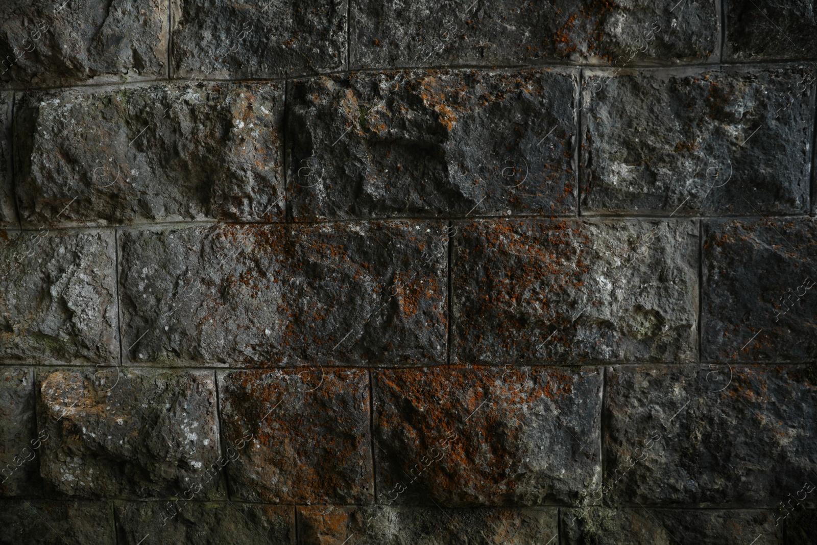 Photo of Texture of dark stone wall as background, closeup