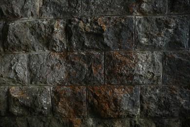 Photo of Texture of dark stone wall as background, closeup