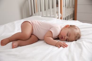 Adorable little baby sleeping on bed at home