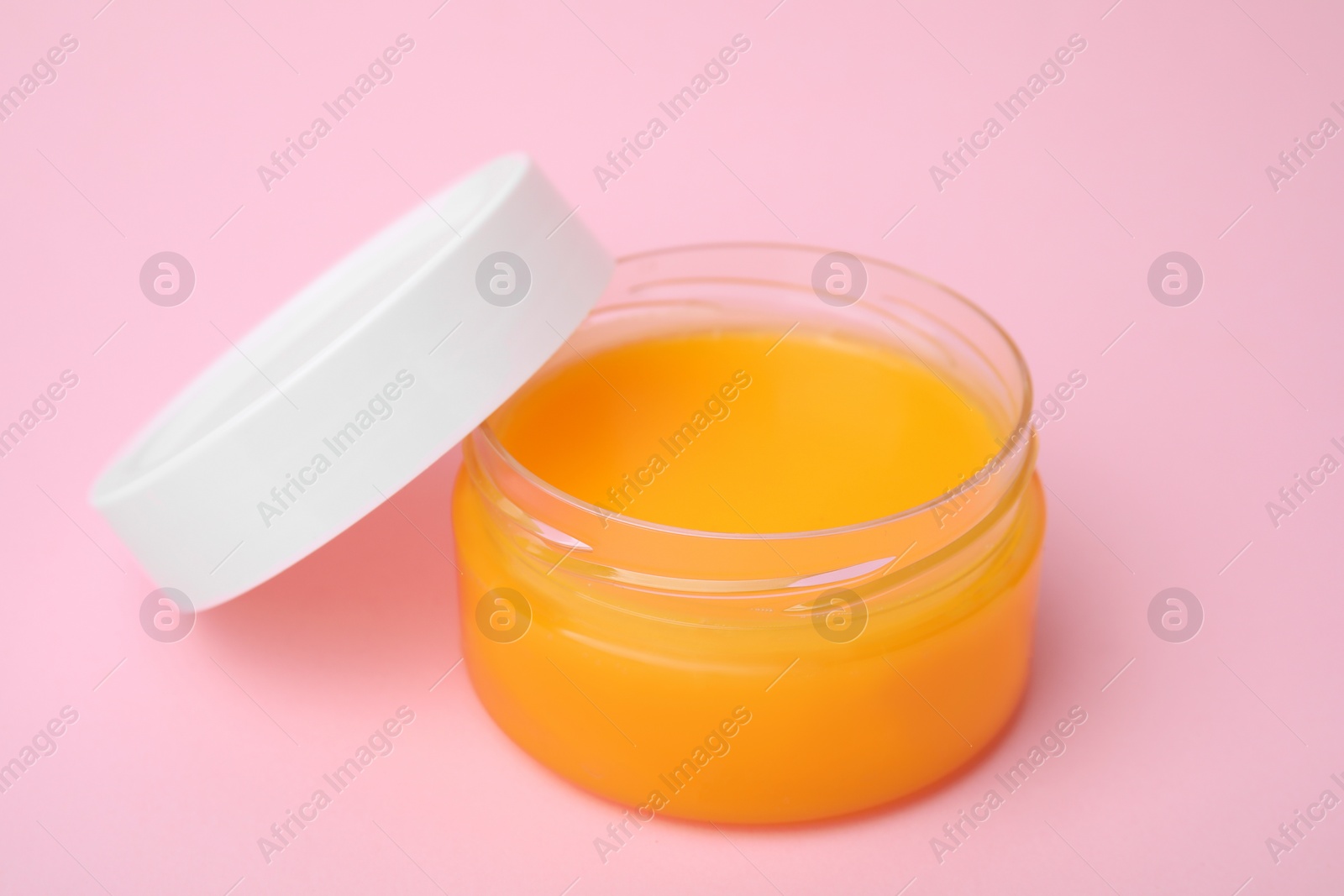 Photo of Open jar with petrolatum on pink background