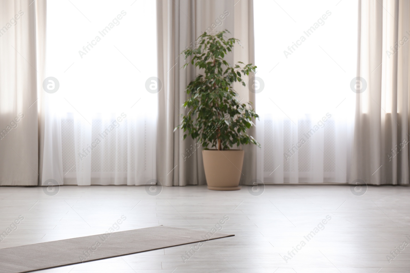 Photo of Grey yoga mat on floor in spacious room