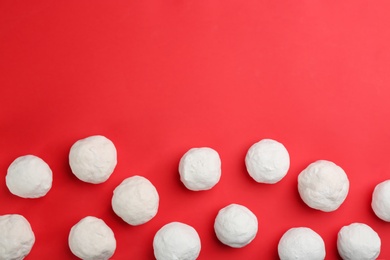 Snowballs on red background, flat lay. Space for text