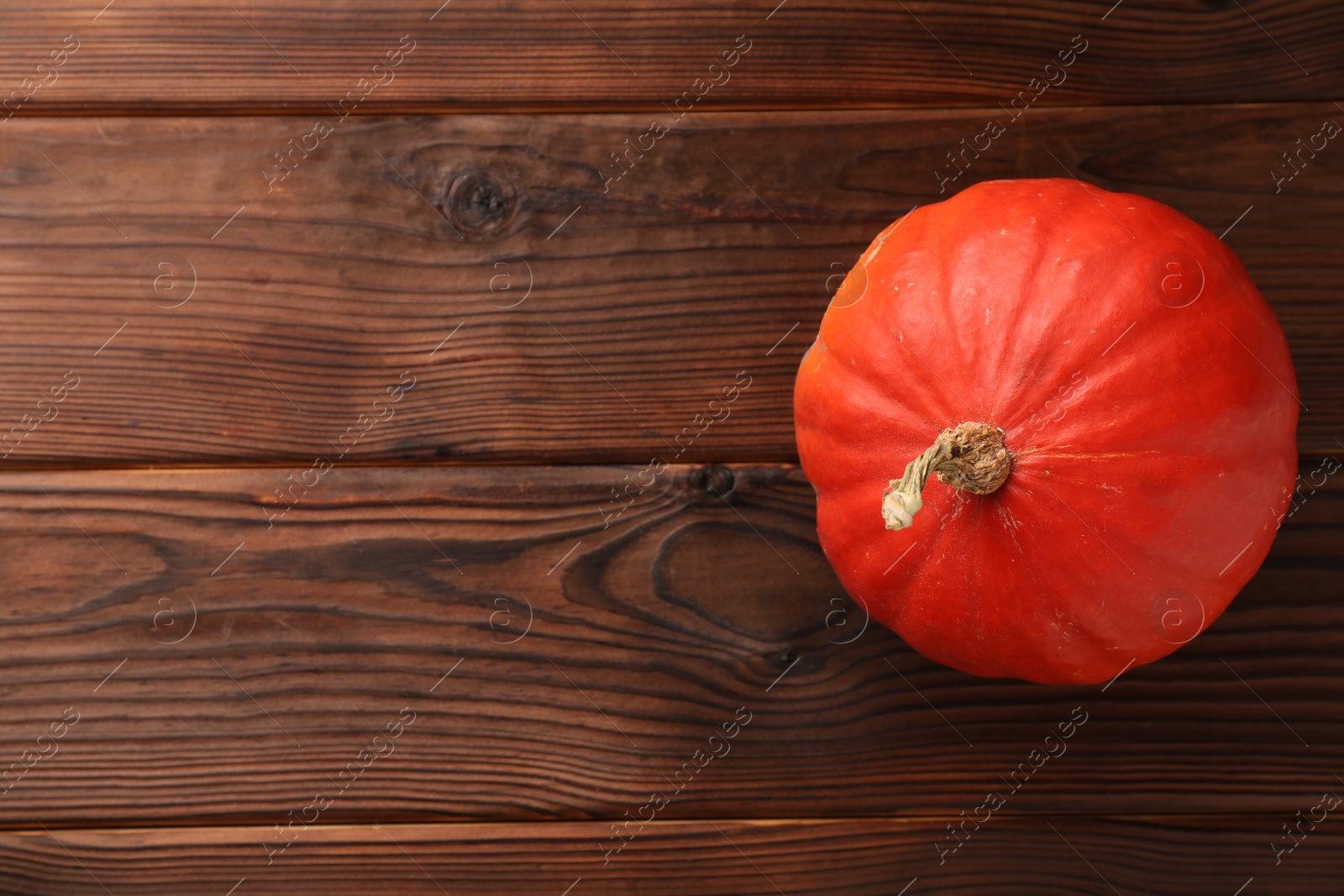 Photo of Fresh orange pumpkin on wooden table, top view. Space for text