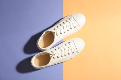 Photo of Pair of stylish sneakers on color background, top view