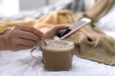 Photo of Woman with cup of morning coffee in bedroom, closeup