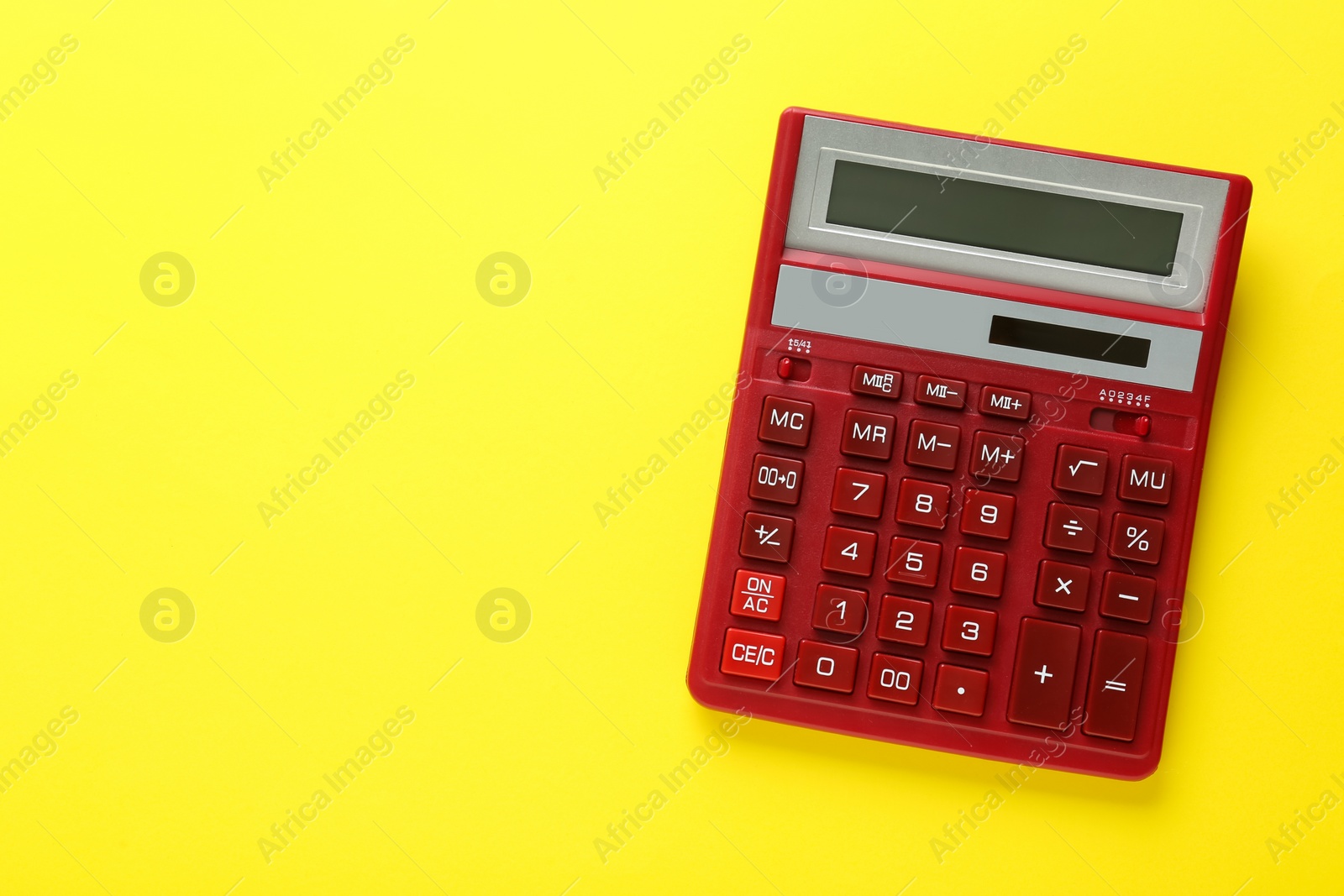 Photo of Red calculator on yellow background, top view. Space for text