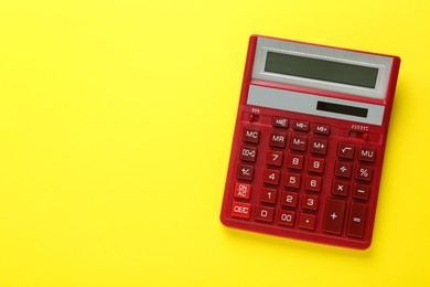 Photo of Red calculator on yellow background, top view. Space for text