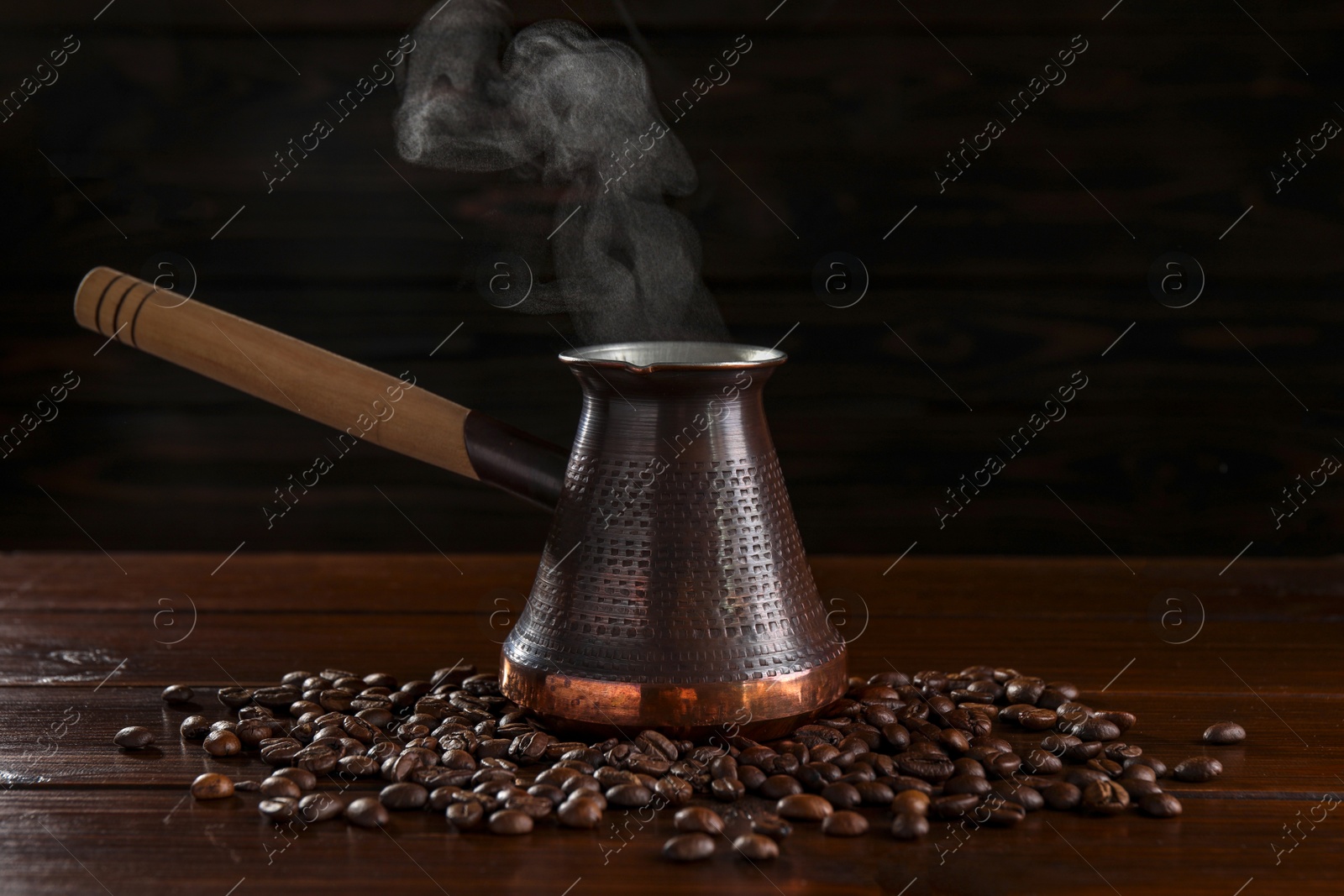 Photo of Turkish coffee in cezve and beans on wooden table