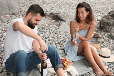 Happy young couple having picnic on beach