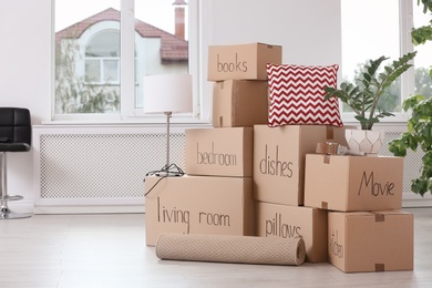 Pile of moving boxes and household stuff indoors