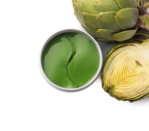 Photo of Package of under eye patches and artichokes on white background, top view. Cosmetic product