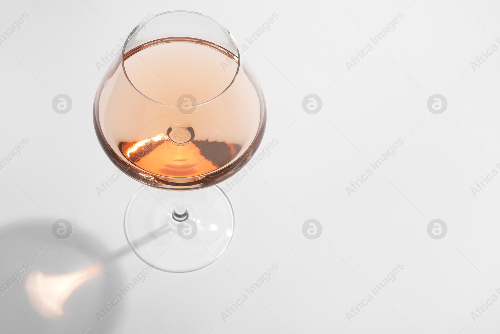 Photo of Tasty rose wine in glass isolated on white