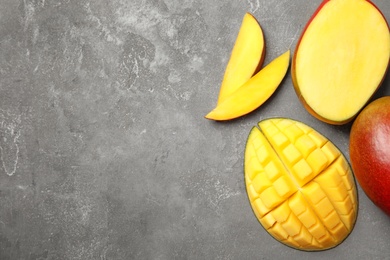 Photo of Flat lay composition with ripe mangoes and space for text on grey background