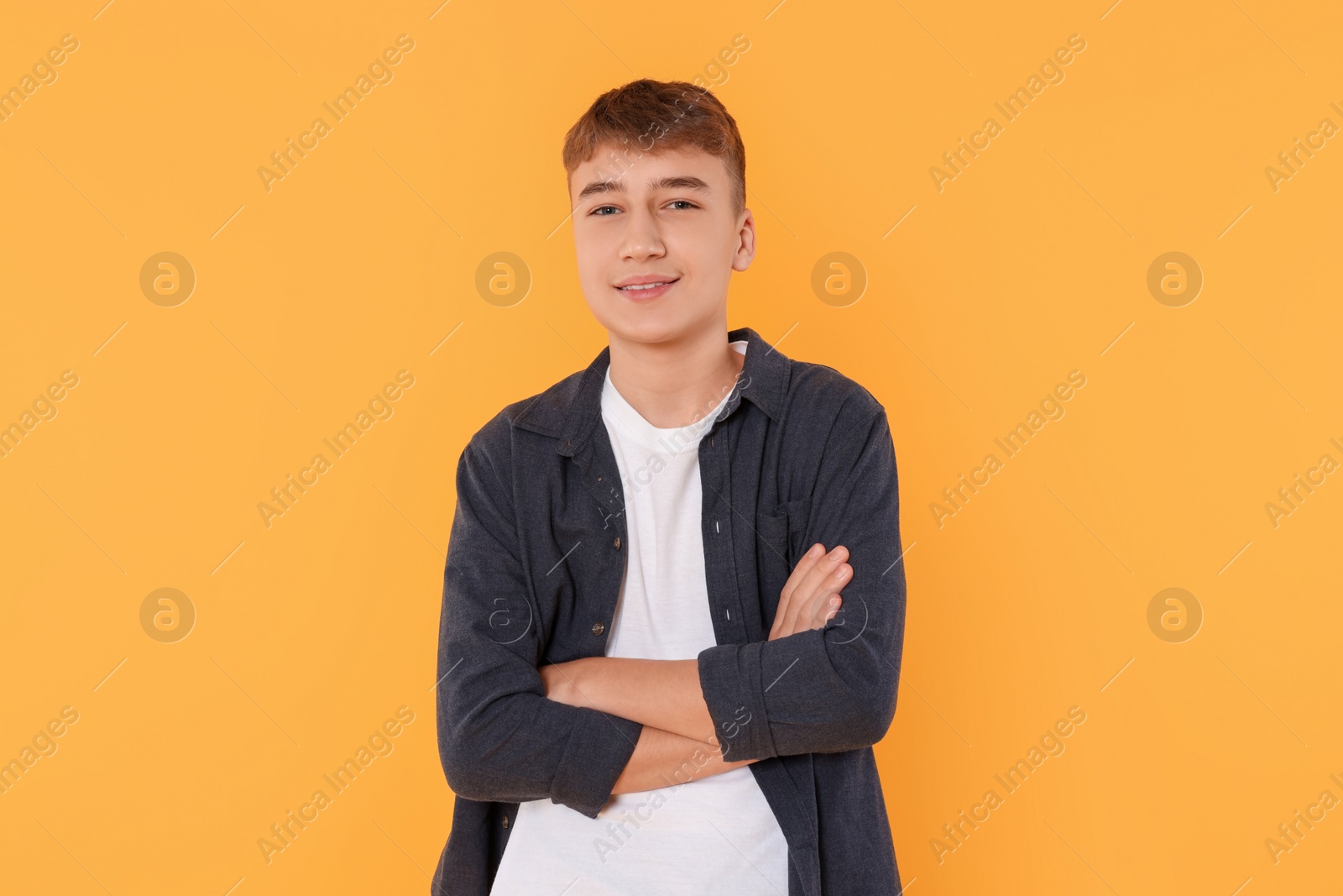 Photo of Portrait of teenage boy on orange background