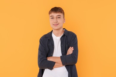 Portrait of teenage boy on orange background