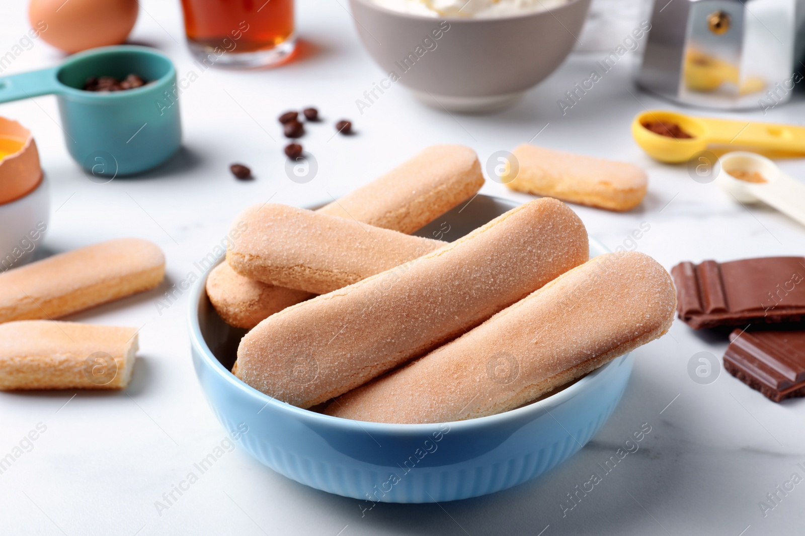 Photo of Tasty cookies and other ingredients for tiramisu on white table