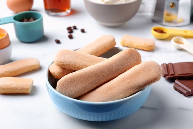 Photo of Tasty cookies and other ingredients for tiramisu on white table