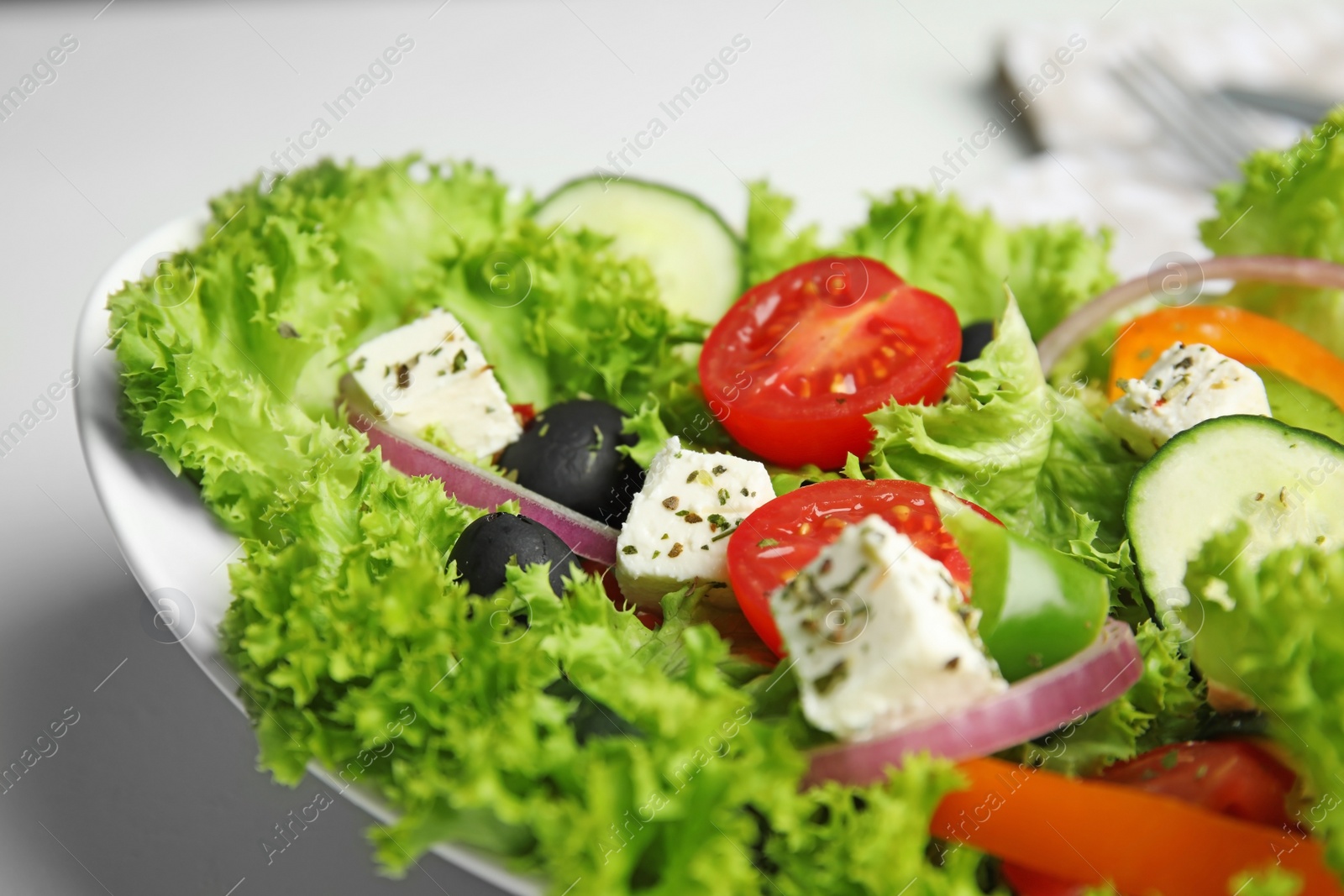 Photo of Tasty fresh Greek salad on white table, closeup