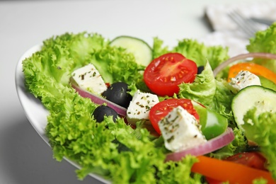 Tasty fresh Greek salad on white table, closeup