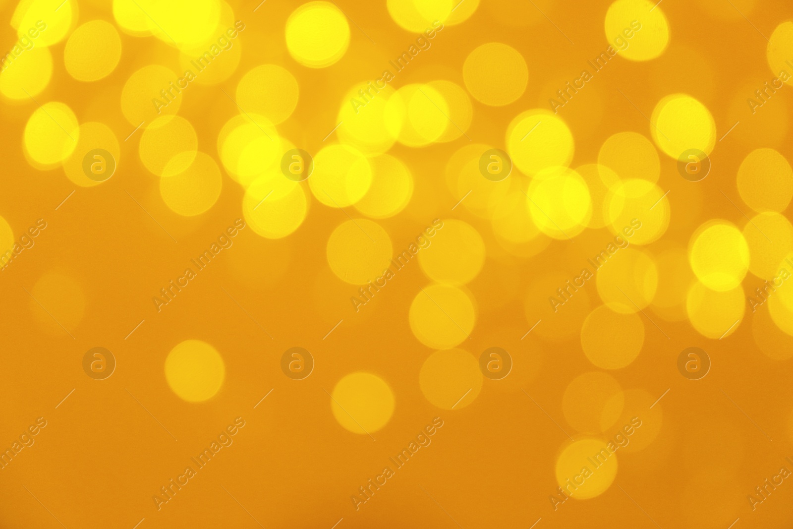 Photo of Blurred view of shiny gold lights. Bokeh effect