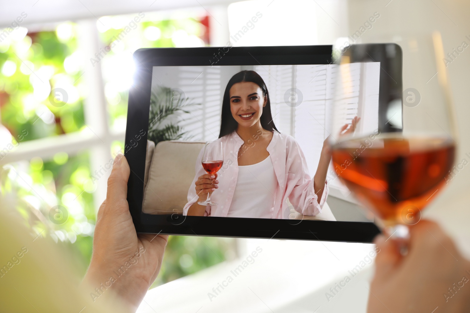 Photo of Friends having video chat and drinking wine together. Online meeting during coronavirus quarantine