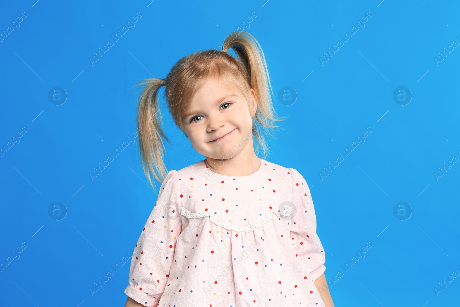 Photo of Portrait of cute little girl on blue background