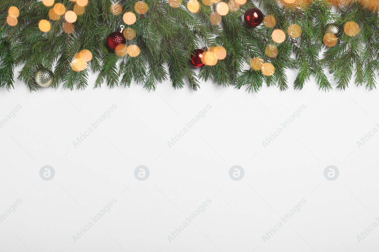 Photo of Flat lay composition with fir tree branches and Christmas decor on white background, space for text. Bokeh effect