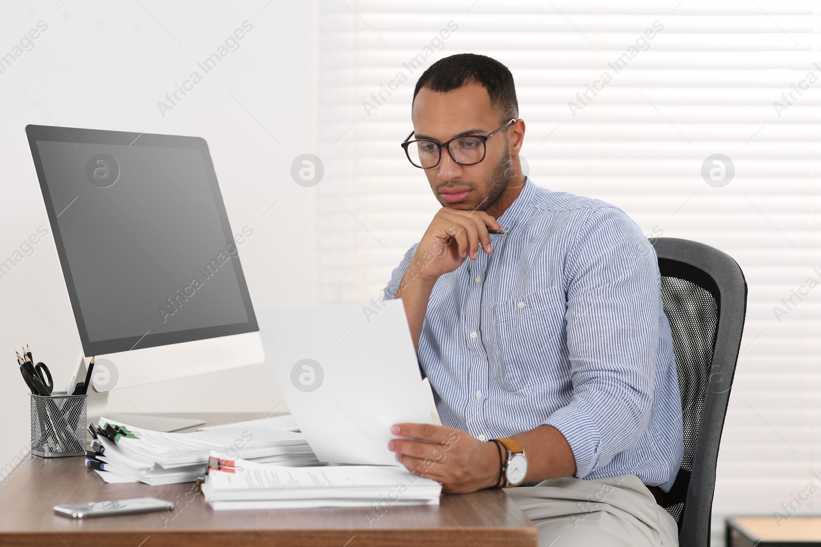 Photo of Businessman working with documents at wooden table in office