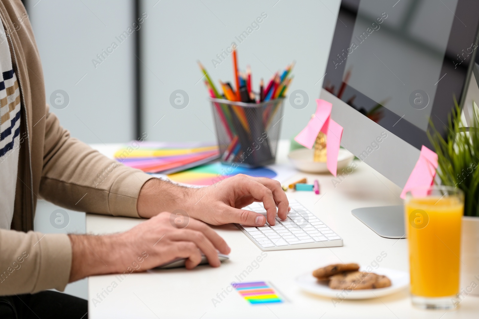 Photo of Male designer working at desk in office, closeup