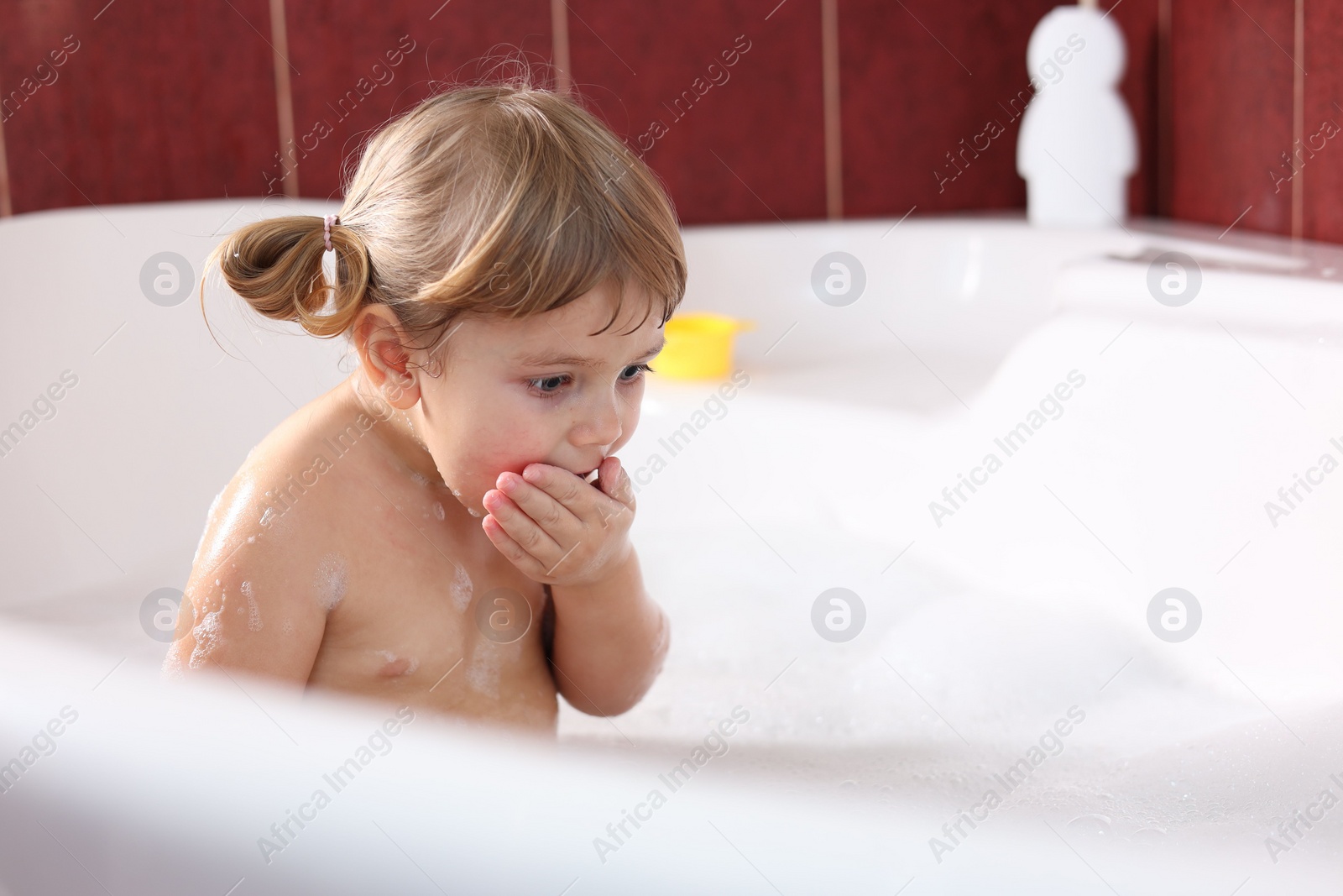 Photo of Little girl bathing in tub at home, space for text