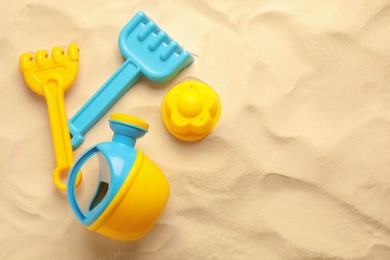 Photo of Flat lay of beach toy kit on sand, space for text. Outdoor play