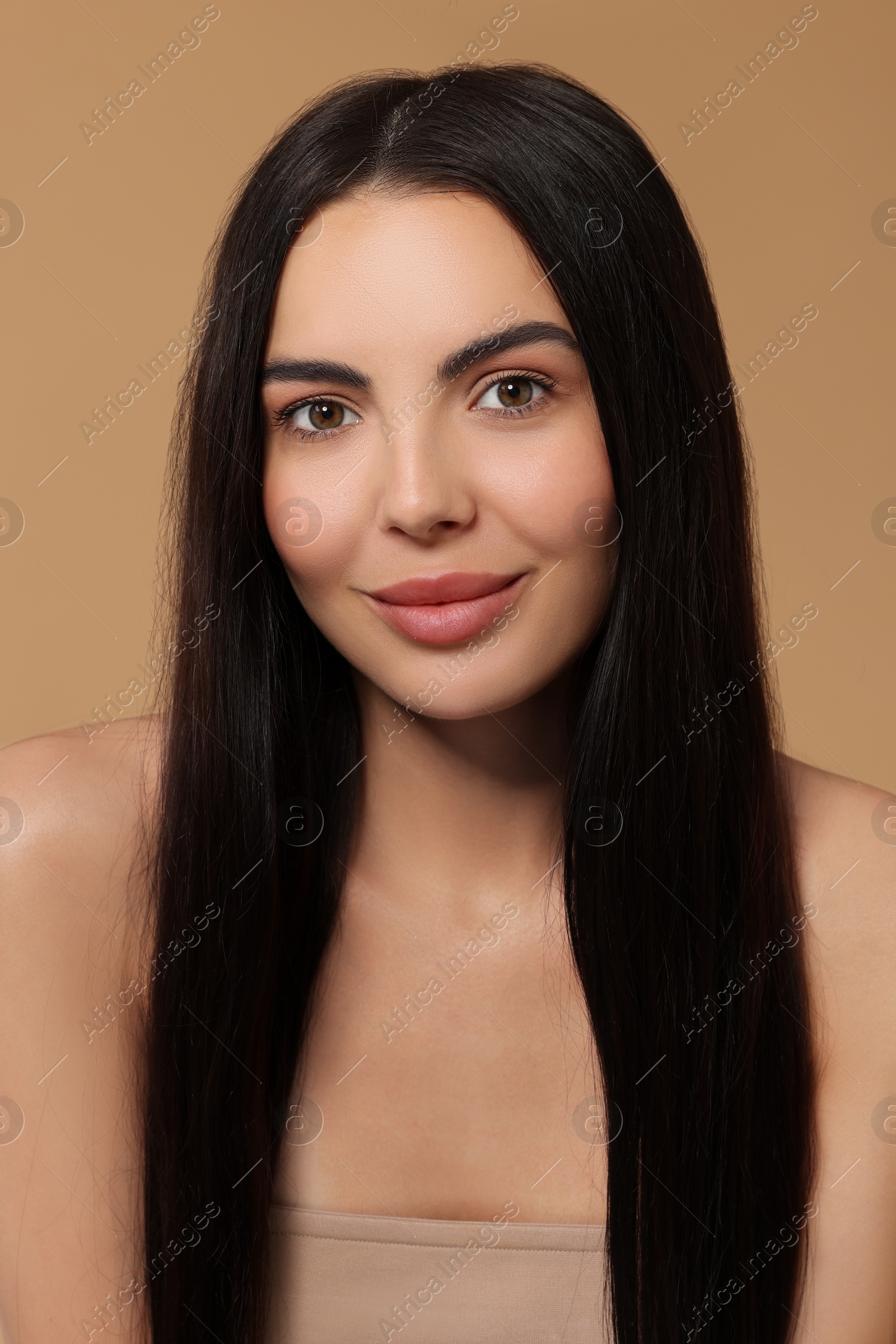 Photo of Beautiful woman with long hair on beige background