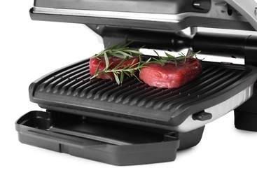 Electric grill with raw meat steaks and rosemary isolated on white