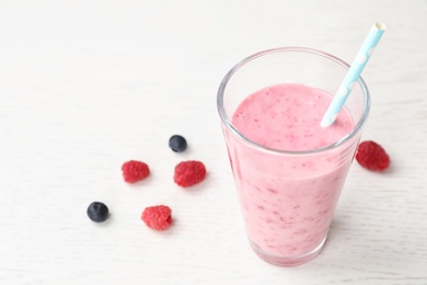 Photo of Delicious smoothie with raspberries in glass on table