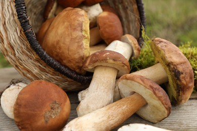 Photo of Fresh wild mushrooms on wooden table outdoors, closeup