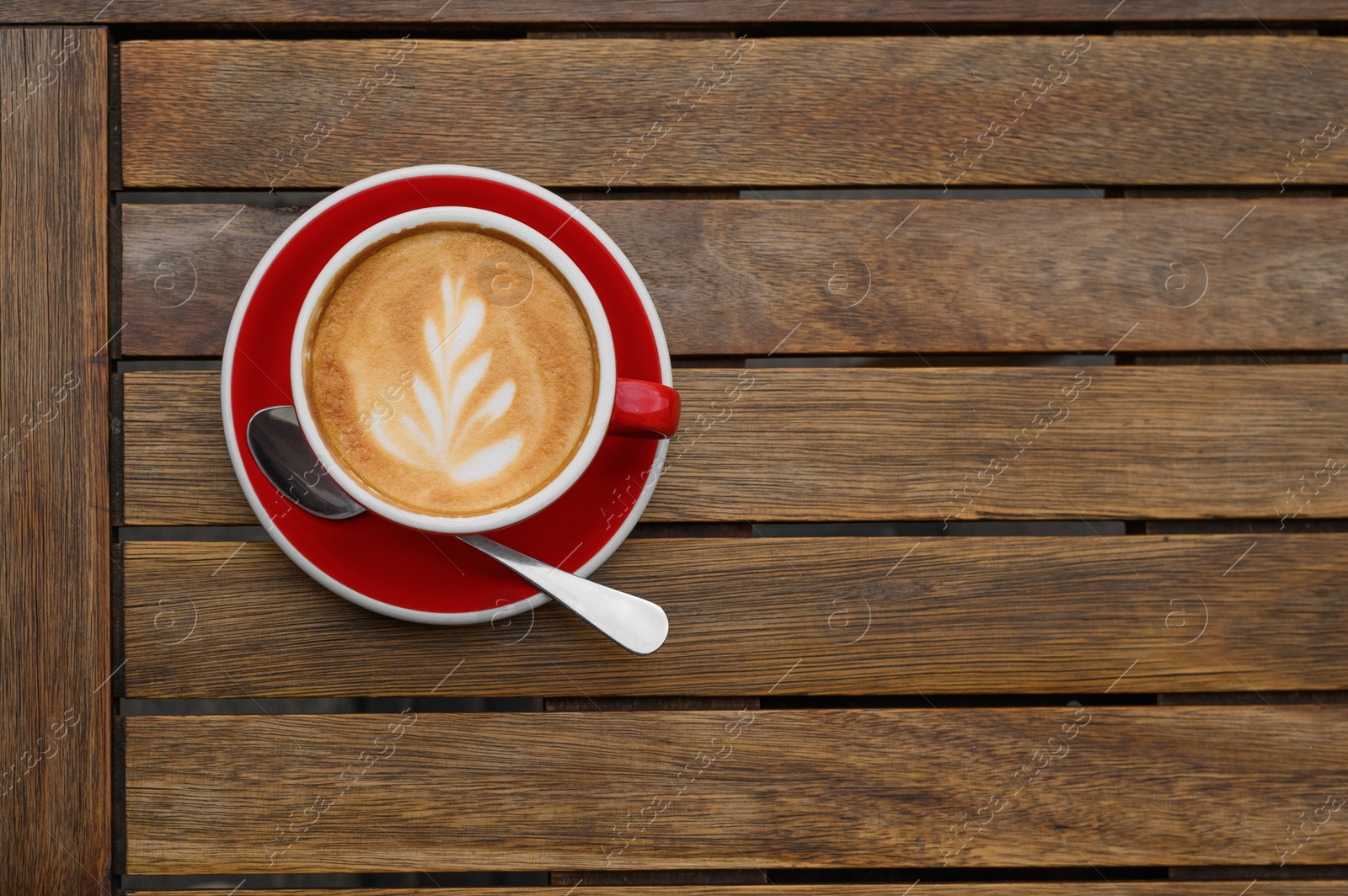 Photo of Cup of aromatic coffee on wooden table, top view. Space for text