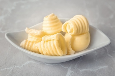 Plate with fresh butter curls on table